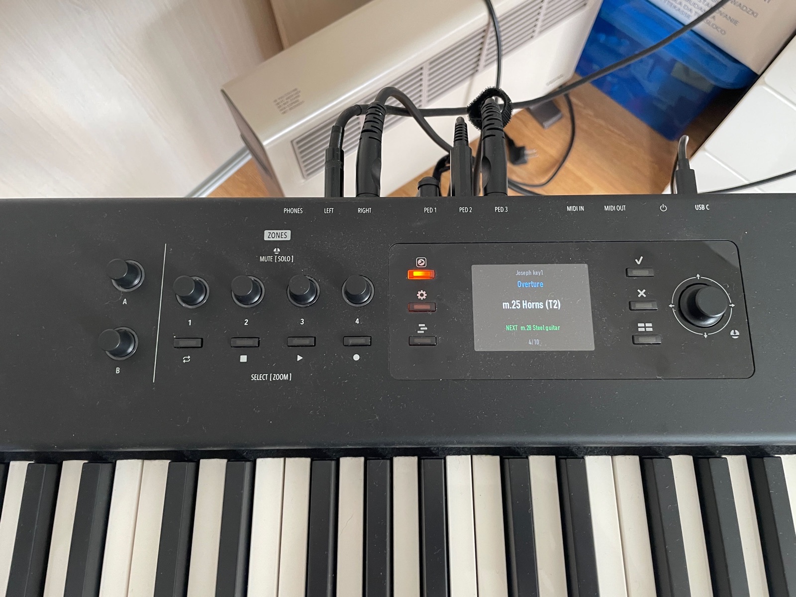 Het scherm van de Studiologic SL88 toont groot de naam van de huidige MainStage-patch en daaronder de volgende patch